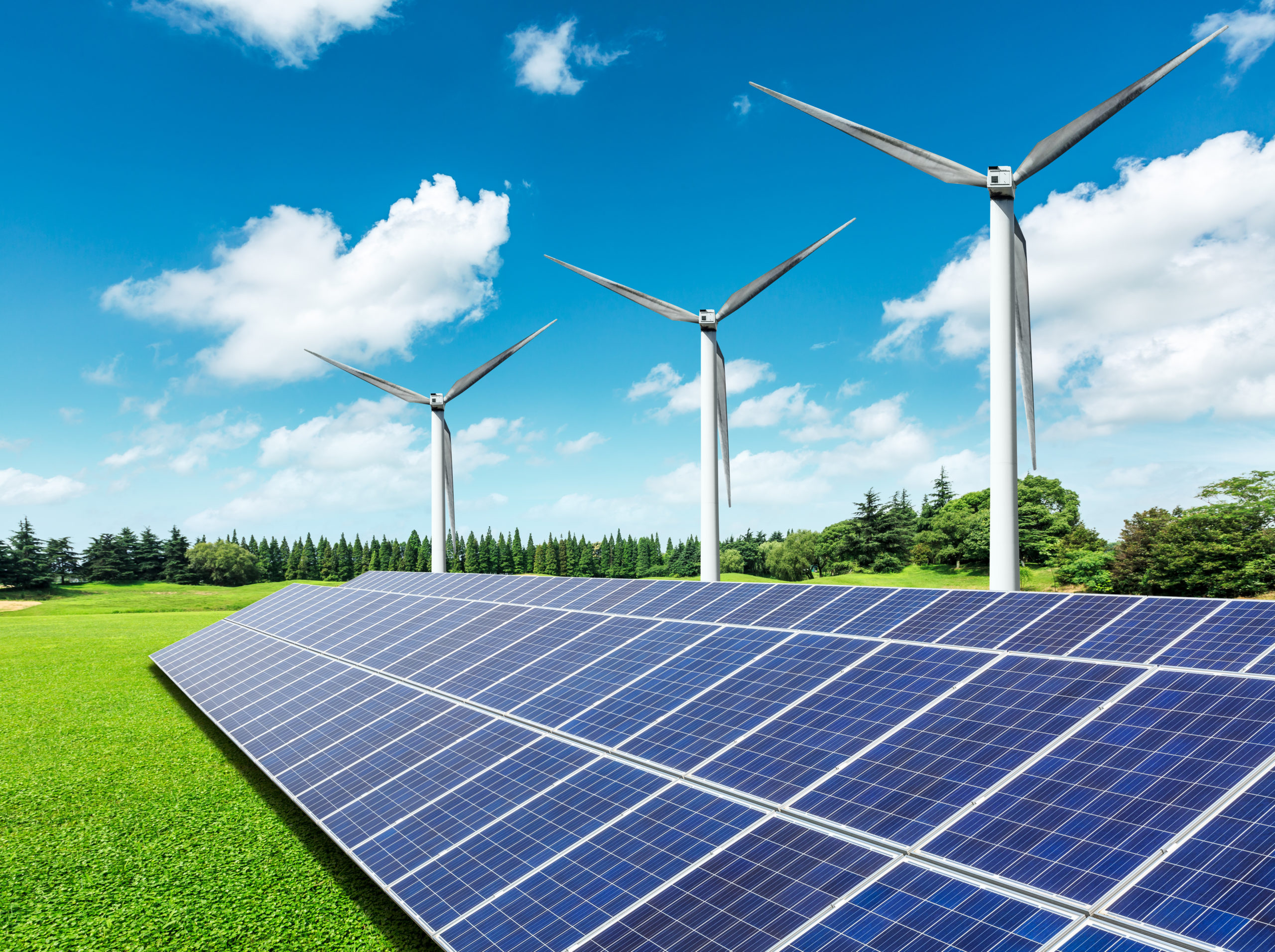 Solar panels and wind turbines in green grass field